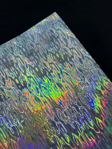 Detailed close-up shot of holographic cardstock with water ripple texture, shiny special paper.