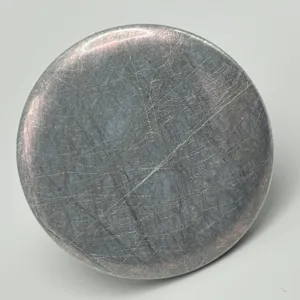 Detailed close-up view of circular holographic badge film featuring unique silk texture and sheen.