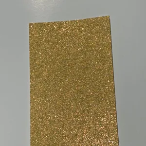Gold glitter cardstock paper detail texture, perfect for custom badge backing and crafts.