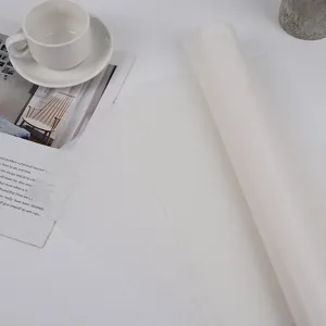 White translucent tissue paper roll and flat sheets detail shot for gift packaging and stuffing.