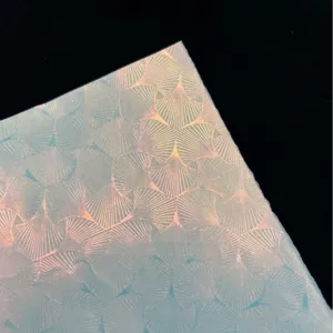 Holographic glitter specialty paper detail, iridescent shell pattern craft paper for badges.