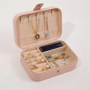 Portable pink PU leather jewelry box organizer with mirror and multi-compartment storage.