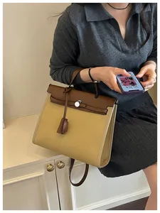 Sac à main chic en toile et cuir avec poignée supérieure et fermeture à verrouillage.