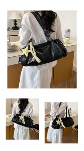 Detailed view of black wrinkled shoulder bag with star charm, showing everyday commuter style.