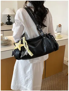 Details of the stylish black leather pleated shoulder bag with cute star charm and strap.