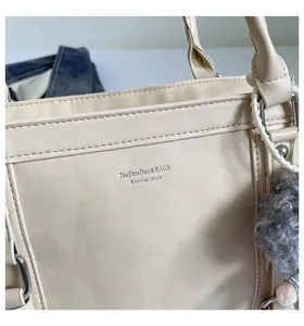 Gedetailleerd close-up van een chique beige PU-leren schoudertas met minimalistische stiksels.