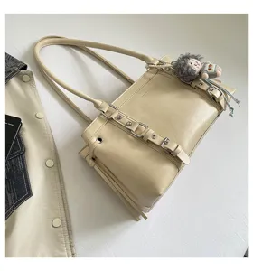 Vintage beige leren schoudertas met chique gesp en schattige pluche poppenhanger voor dames.