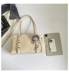 Gedetailleerd overzicht van de retro beige schoudertas met metalen gespen en pop.
