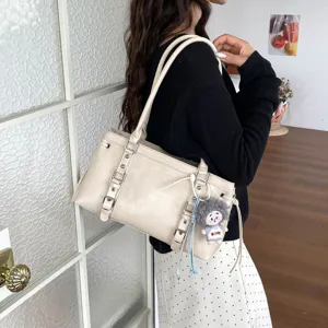 Beige lederen schoudertas voor dames, grote stijlvolle handtas met gespdecoratie.