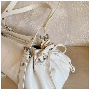 Detail view of white pleated women tote bag, stylish commuter shoulder handbag with vintage style.
