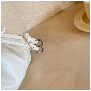 White pleated shoulder bag detail featuring elegant knots and metal rings for women commute.