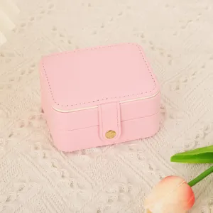 Gros plan détaillé de la boîte à bijoux portable en cuir PU rose avec coutures et bouton pression.