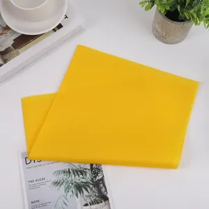 Close-up detail of soft yellow tissue paper for gift wrapping and floral packaging setup.