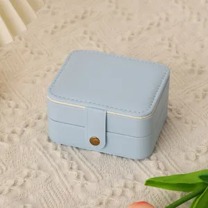 Détail de boîte à bijoux en cuir PU bleu clair, étui de rangement portable avec bouton.