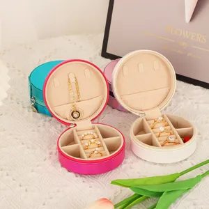 Portable round PU leather jewelry box organizer with multi compartments for rings and earrings.