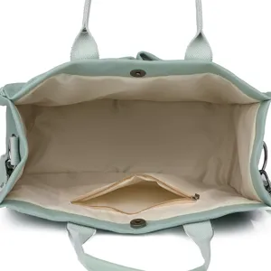 Interior detail of the mint green canvas tote bag, showing zipper pocket and roomy space.