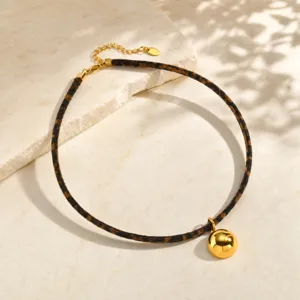 Elegante collar gargantilla con estampado de leopardo y colgante de esfera dorada brillante.