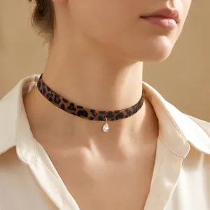 Primer plano de un collar gargantilla ancho con estampado de leopardo para mujer con colgante.