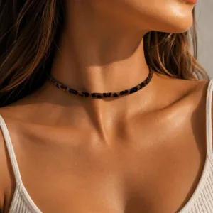 Primer plano detallado de un elegante collar gargantilla con estampado de leopardo en cuello.