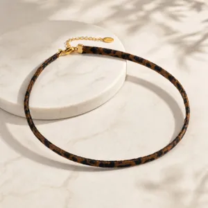 Detalle del collar gargantilla con estampado de leopardo y cierre metálico dorado.