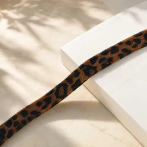 Detalle de correa de peluche con estampado de leopardo, textura suave. Elegante diseño.