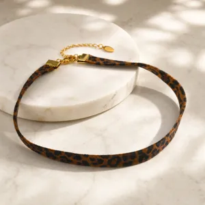 Elegante collar choker de terciopelo con estampado de leopardo y detalles de acero dorado.