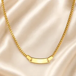 Close-up of golden stainless steel curb chain necklace with smooth blank curved ID tag detail.