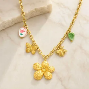 Primer plano detallado del collar de acero inoxidable bañado en oro de 18k con dijes florales.