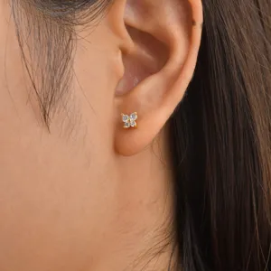 Close-up detail shot of dainty clover stud earrings featuring sparkling cubic zirconia stones.