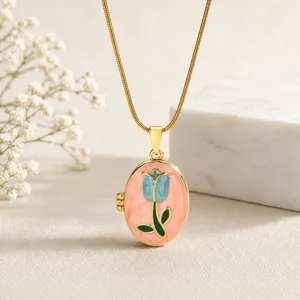 Nahaufnahme einer vergoldeten Messing-Medaillon-Halskette mit rosa und blauem Emaillestift.