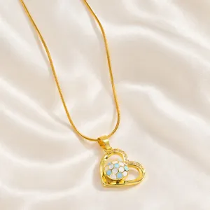 Vista ravvicinata dettagliata della collana con ciondolo a cuore in oro e pallone da calcio.