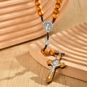 Vintage wood bead rosary necklace detail featuring alloy crucifix and Saint Benedict medal.