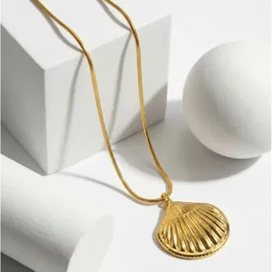 Primo piano dettagliato di una collana con catena a serpente dorata e ciondolo a conchiglia.