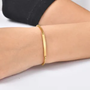 Vista de detalle en primer plano del brazalete de cadena con placa de identificación curva.