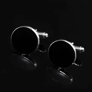 Detailed view of classic round black silver French cufflinks, elegant accessory for formal shirts.