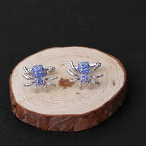 Boutons de manchette araignée argentés avec strass bleus pour chemise habillée d'homme élégant.