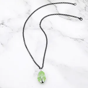 Collana con ciondolo albero della vita in resina fiore secco e catena nera, primo piano dettagliato.