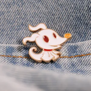 Dettaglio ravvicinato di spilla smaltata fantasma bianco, simpatica spilla cartoon su denim.