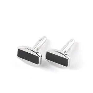 Boutons de manchette élégants en métal argenté avec insert noir pour chemises formelles.