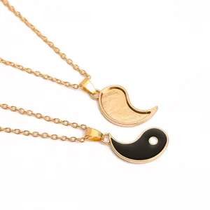 Detailed close-up view of matching yin yang couple split pendant necklaces in gold tone.