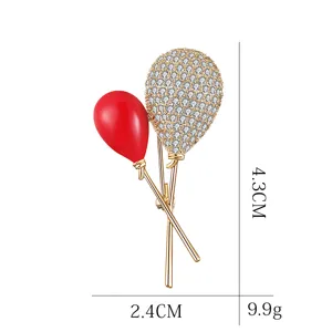 Exquisite balloon shape brooch detail, gold-plated metal with red enamel and sparkling rhinestones.