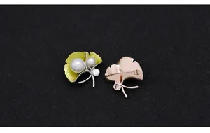 Exquisite ginkgo leaf pearl brooch featuring dual pearls and rhinestones, elegant clothing accessory.