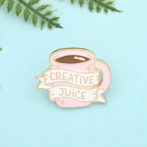 Detailed view of the cute pink coffee cup enamel pin, featuring creative juice text.