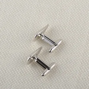 Vue détaillée de boutons de manchette en métal argenté, design en goutte, accessorio chic.