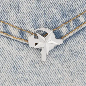 Gros plan de la broche étoile en alliage sur denim, détail d'épingle de col élégant.