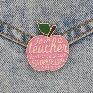 Teacher apple enamel pin close-up, cute pink lapel badge detail, creative gift accessory.