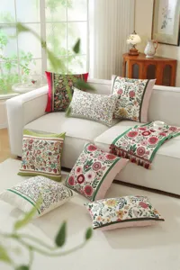 Detailed view of jacquard floral pattern throw pillow covers and cushion runner on white sofa.
