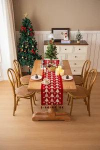 Decorazione per tavola natalizia con runner jacquard rosso e alberello festivo.