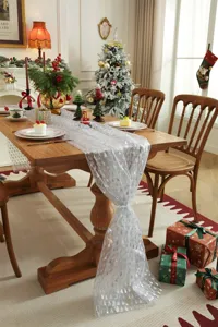 White mesh Christmas table runner with silver tree print, elegant holiday dining decor.