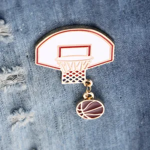 Detailed view of a stylish metal basketball hoop brooch with hanging charm, perfect fashion accessory.